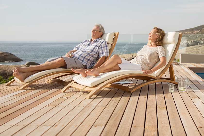 Older couple relaxing in lawn chairs by pool Older couple relaxing in lawn chairs by pool