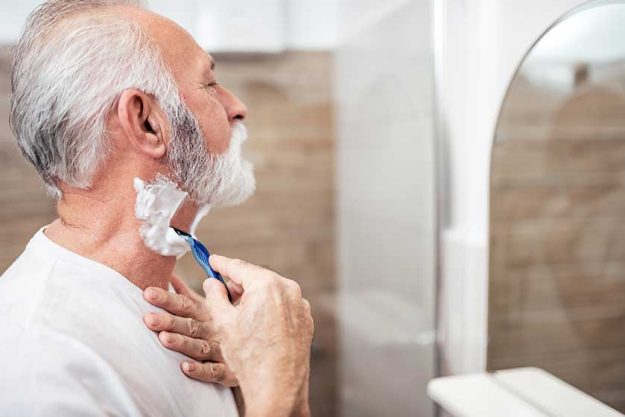 Side view of senior man shaving. Side view of senior man shaving.