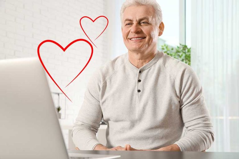 Mature man visiting dating site via laptop indoors