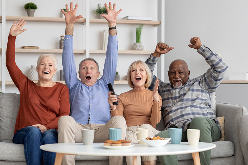 Happy multiracial elderly people watching football