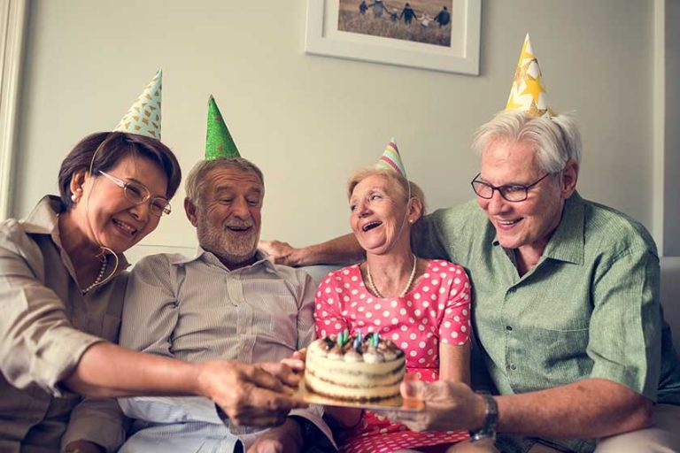 Senior people holding birthday cake