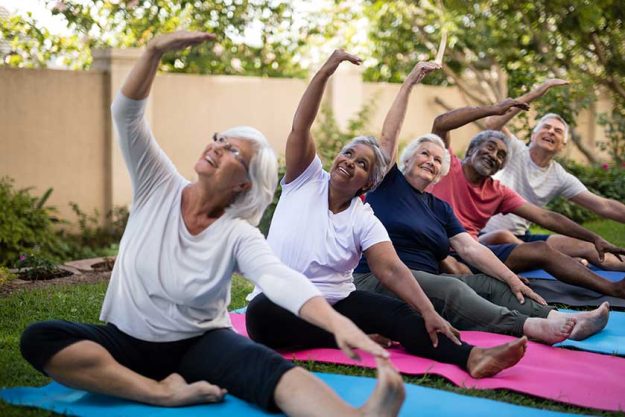 Senior people with arms raised exercising