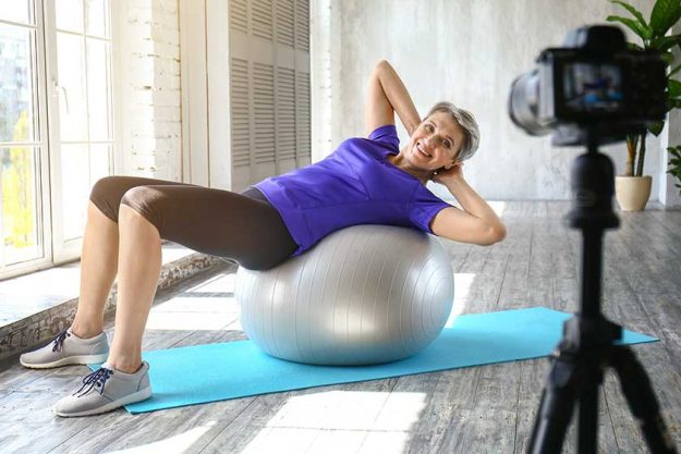 Sporty mature woman training with fitball at home Sporty mature woman training with fitball at home