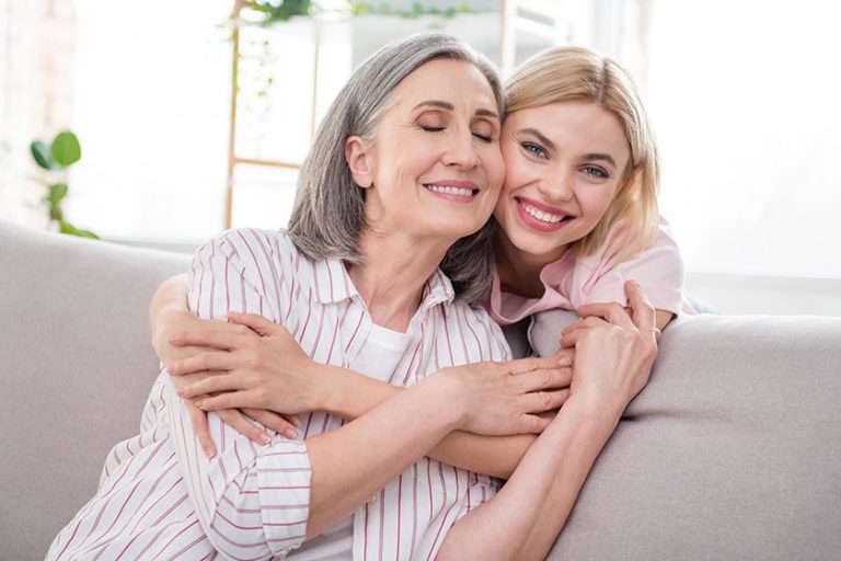 Portrait of two attractive sweet dreamy cheerful women granddaughter hugging granny