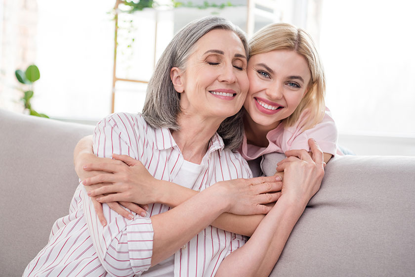 Portrait of two attractive sweet dreamy cheerful women granddaughter hugging granny