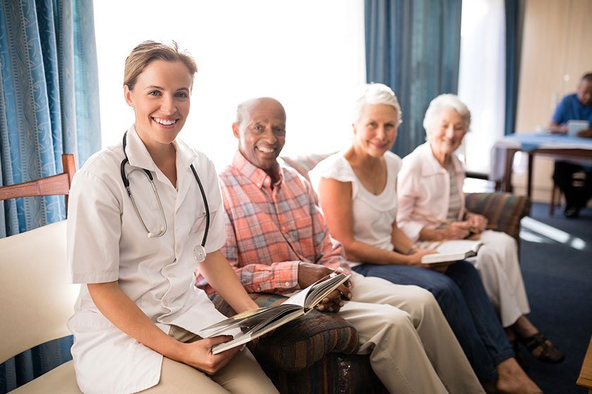 Female doctor sitting with senior man and women