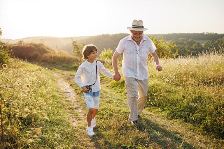 Photo of little boy and his grandfather walking
