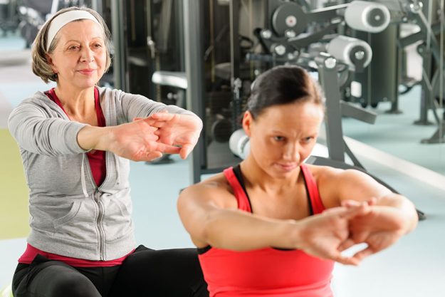 Two women at gym stretch out Two women at gym stretch out