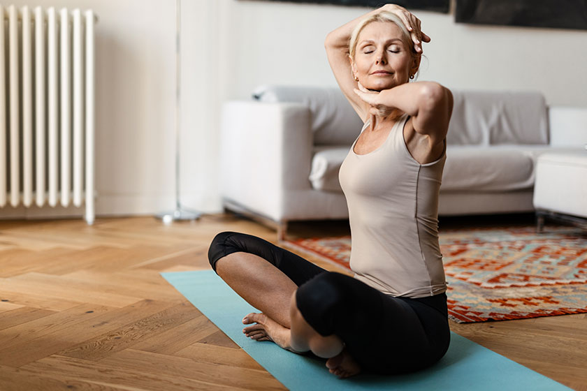 Blonde mature woman doing exercise during yoga practice at home Blonde mature woman doing exercise during yoga practice at home