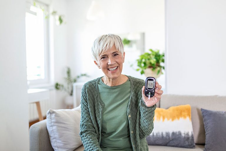 Blood sugar testing at home. Checking Blood Sugar Level At Home. Diabetic Checking Blood Sugar Levels. Woman checking blood sugar level by glucometer and test stripe at home