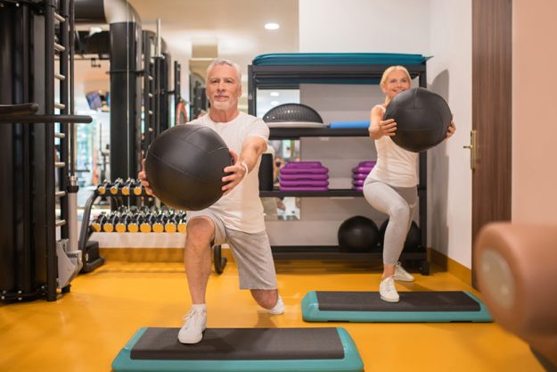A man and a woman doing lunging with balls