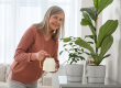 senior-woman-watering-beautiful-potted-houseplants