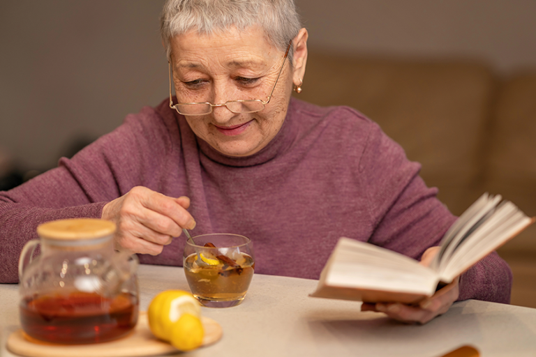 woman-sitting-table-drinking-tea-lemon-reading-book