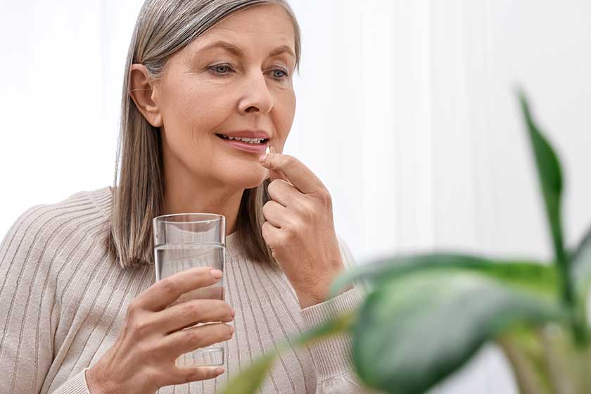 Beautiful-woman-taking-vitamin-pill-at-home
