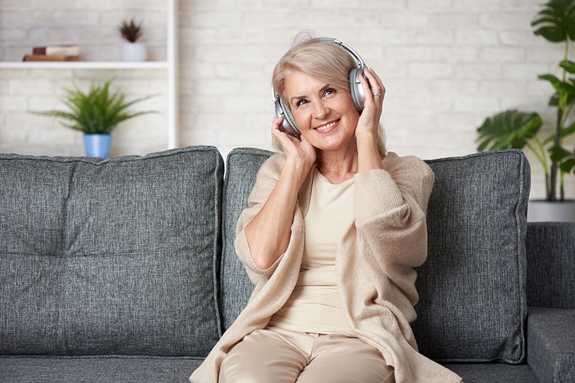 Carefree senior woman is listening to music