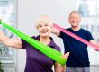 Elderly couple in senior gymnastic class doing workout with rub