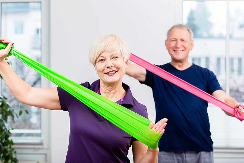 Elderly couple in senior gymnastic class doing workout with rub