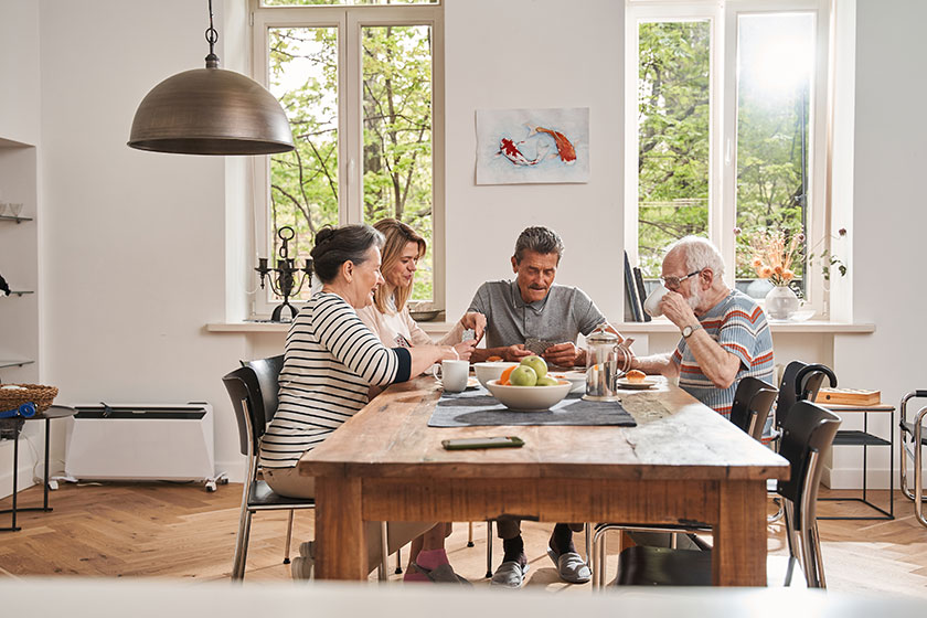 Pensioners sitting at the table with their caregiver