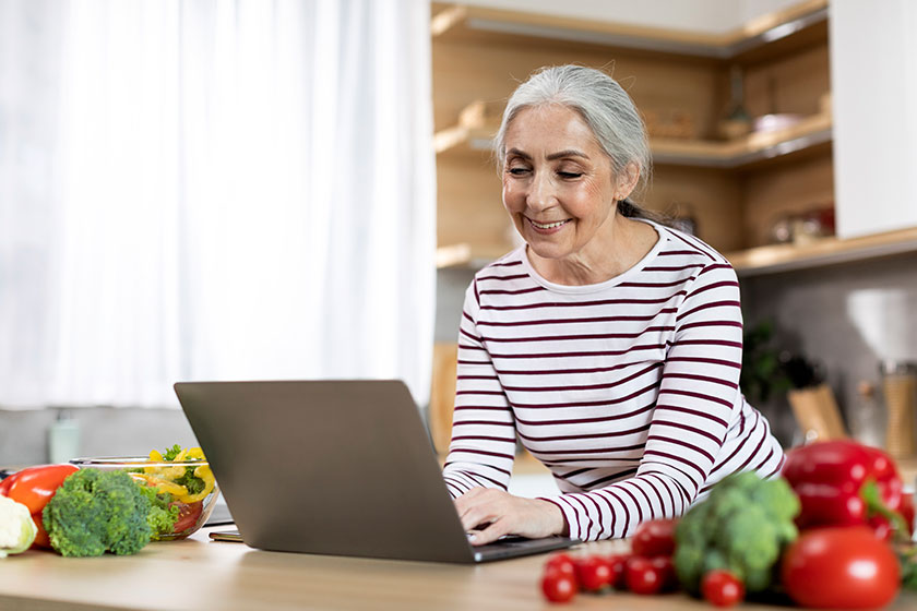 Portrait Of Smiling Elderly Lady Using Laptop Portrait Of Smiling Elderly Lady Using Laptop