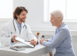 Cheerful doctor showing good test results to senior patient