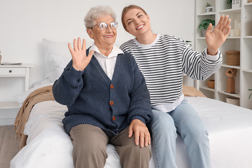 happy-senior-woman-her-granddaughter-waving-hands Happy senior woman and her granddaughter waving