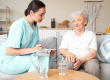 Physical therapist writing in clipboard with senior woman