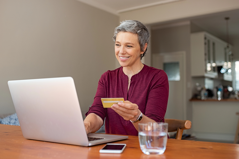 Happy senior woman making online payments of bill